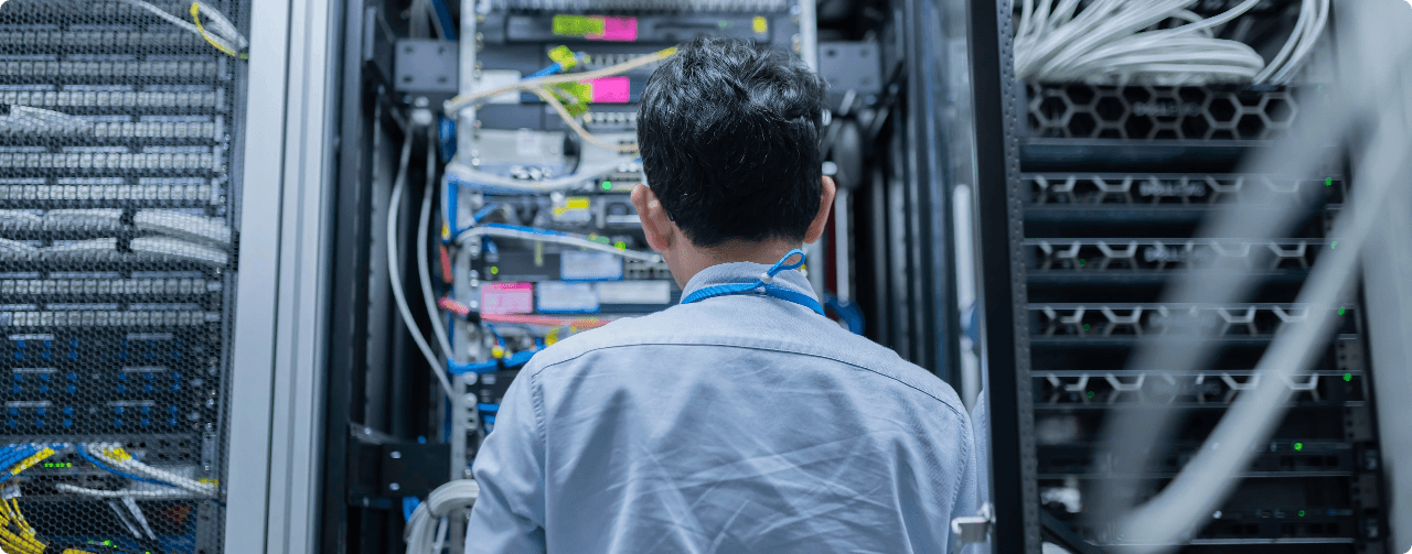 IT engineer working on cabling and hardware inside an enterprise server rack