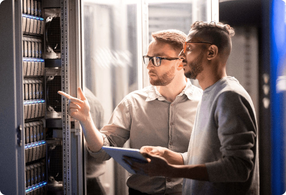 Two engineers troubleshooting in the server room — where uptime meets teamwork.