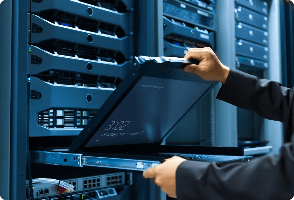 IT technician opening rack-mounted KVM console laptop in a data center server room, screen displaying 3:02 lock screen