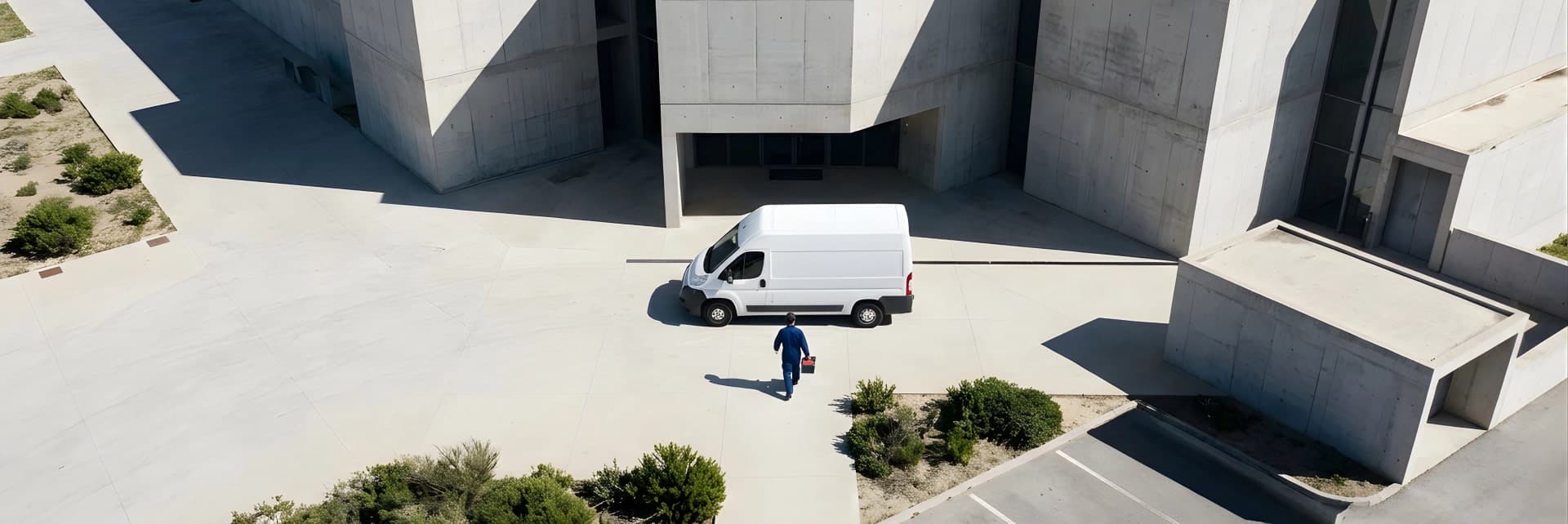 Dramatic aerial view of a modern concrete architectural structure with sharp angular walls and shadows