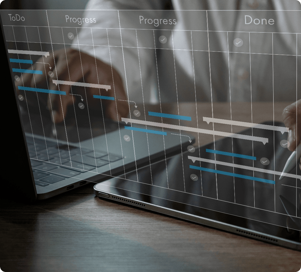 Male hands working at a laptop and tablet close up with overlayed schedule/planning graphics